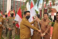 Wakil Bupati Kukar, Rendi Solihin saat melakukan penyerahan bendera secara simbilis dalam rangka Gerakan 10 Juta Bendera Merah Putih. (Foto: Ist)