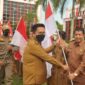 Wakil Bupati Kukar, Rendi Solihin saat melakukan penyerahan bendera secara simbilis dalam rangka Gerakan 10 Juta Bendera Merah Putih. (Foto: Ist)
