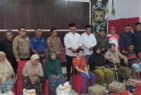 Kepala Dinas Pemberdayaan Masyarakat Dan Desa (DPMD) Kukar, Arianto, S.Sos., M.Si, bersama Bupati Kukar, Edi Damansyah menyerahkan bantuan pangan dan sosial kepada warga Desa Loa Janan Ulu. (Foto: Ist)
