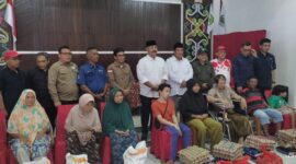 Kepala Dinas Pemberdayaan Masyarakat Dan Desa (DPMD) Kukar, Arianto, S.Sos., M.Si, bersama Bupati Kukar, Edi Damansyah menyerahkan bantuan pangan dan sosial kepada warga Desa Loa Janan Ulu. (Foto: Ist)