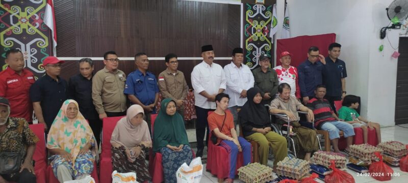 Kepala Dinas Pemberdayaan Masyarakat Dan Desa (DPMD) Kukar, Arianto, S.Sos., M.Si, bersama Bupati Kukar, Edi Damansyah menyerahkan bantuan pangan dan sosial kepada warga Desa Loa Janan Ulu. (Foto: Ist)