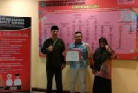 Kepala DPMD Kukar Arianto memegang piagam penghargaan atas indeks profesionalitas ASN terbaik ke-1 dari Pemkab Kukar. (Foto: Ist)