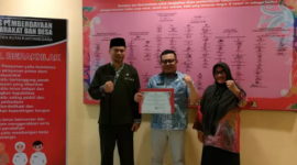 Kepala DPMD Kukar Arianto memegang piagam penghargaan atas indeks profesionalitas ASN terbaik ke-1 dari Pemkab Kukar. (Foto: Ist)