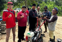 Bupati Edi Damansyah menyerahkan alat mesin pertanian jenis cultivator kepada petani. (Foto: Ist)