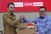 Kepala DPMD Kukar, Arianto, menyerahkan dokumen serah terima kepada Kepala Desa Rapak Lambur, Muhammad Yusuf. (Foto: Ist)