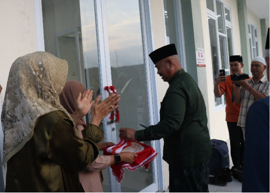Bupati Kukar Edi Damansyah menyerahkan kartu peserta Bimtek Juru Sembelih Halal dan meresmikan sejumlah fasilitas masjid. (Foto: Ist)
